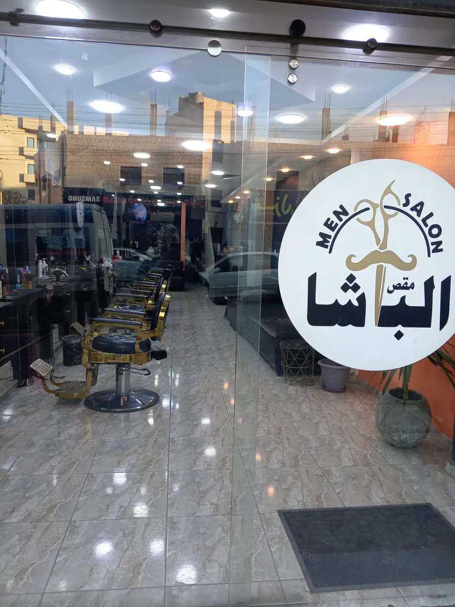 مدخل صالون مقص الباشا الزجاجي مع شعار الصالون الذهبي